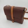 Bolso mediano de piel marron oscuro visto en escorzo